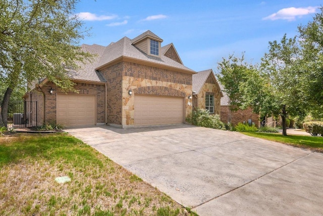 8813 Fescue Ln, Austin, TX 78738 - view of front of property with a garage, driveway, cooling unit, stone siding, and brick siding