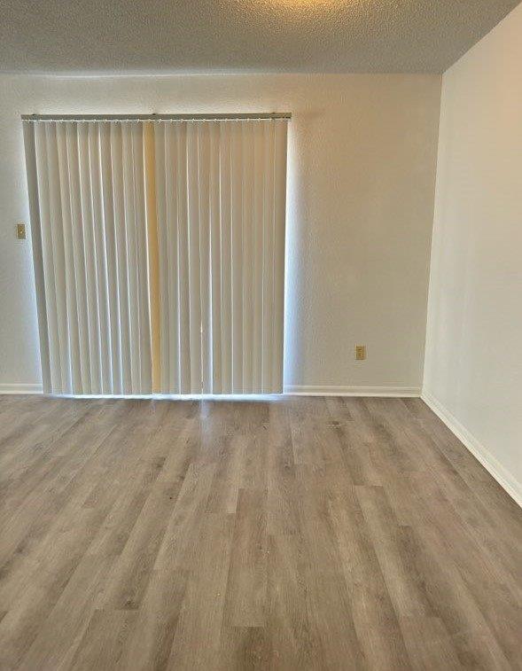 empty room featuring baseboards and wood finished floors