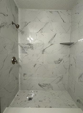 full bathroom featuring tiled shower