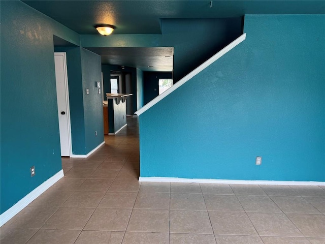 spare room with tile patterned flooring and baseboards
