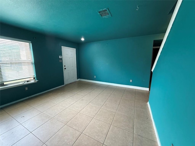 tiled spare room with baseboards, visible vents, recessed lighting, and a textured ceiling