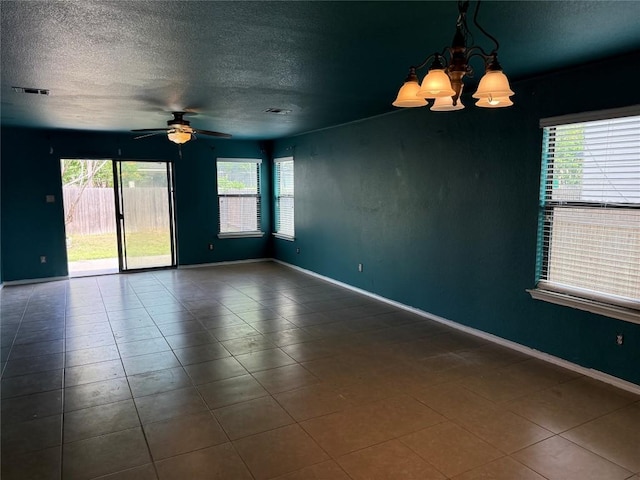 unfurnished room featuring a healthy amount of sunlight, a textured ceiling, visible vents, and ceiling fan with notable chandelier