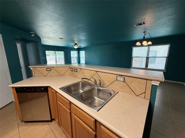 kitchen featuring stainless steel dishwasher, a textured ceiling, visible vents, and a sink