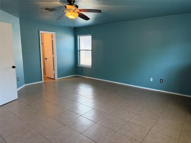 unfurnished room with tile patterned floors, baseboards, visible vents, and ceiling fan