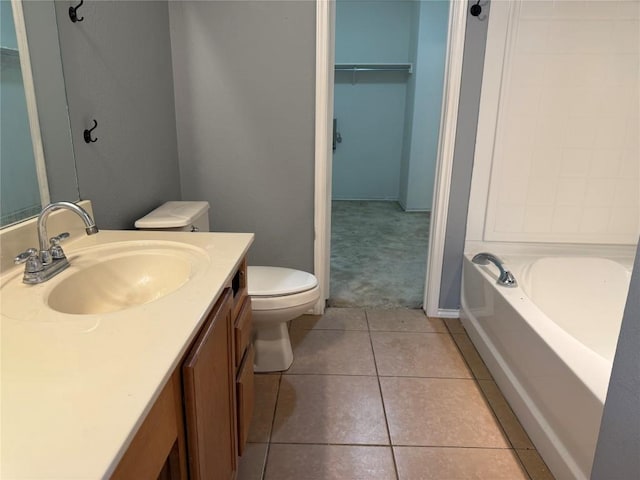 full bathroom with tile patterned flooring, a spacious closet, toilet, and vanity