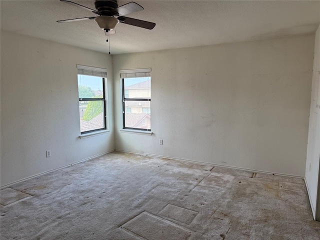 spare room featuring carpet flooring and a ceiling fan
