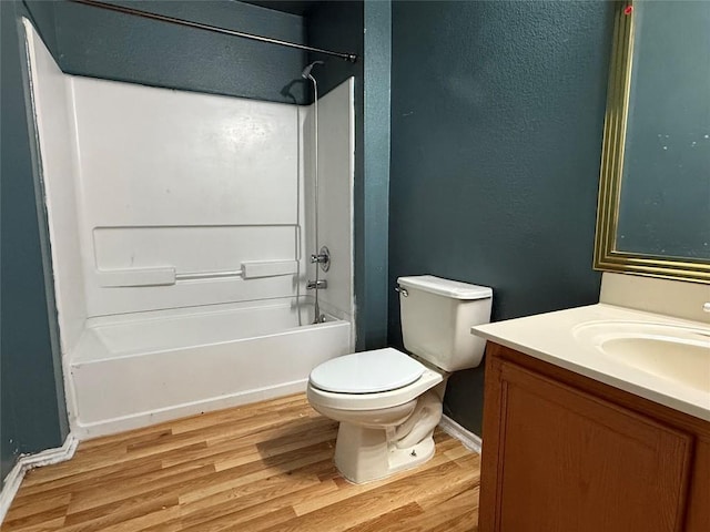 full bath featuring  shower combination, toilet, baseboards, wood finished floors, and vanity