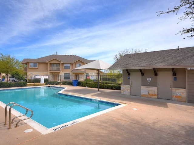 community pool with fence and a patio area