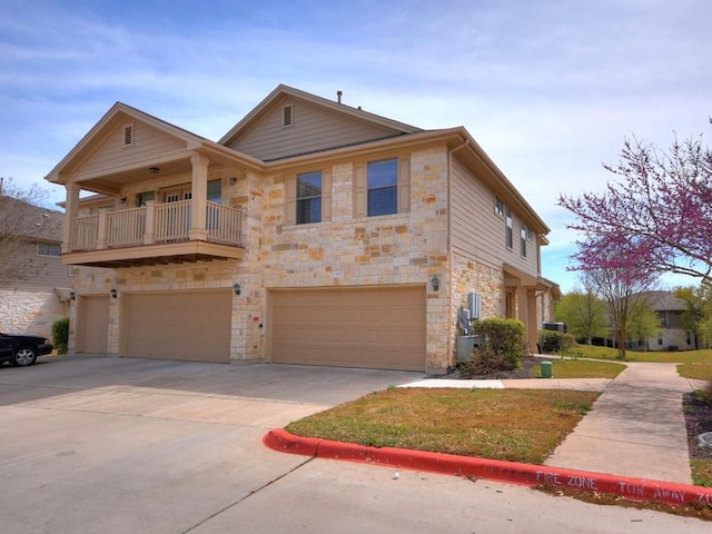 view of front of property featuring an attached garage, stone siding, and concrete driveway