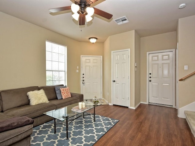 living room with stairway, ceiling fan, baseboards, dark wood-style flooring, and visible vents