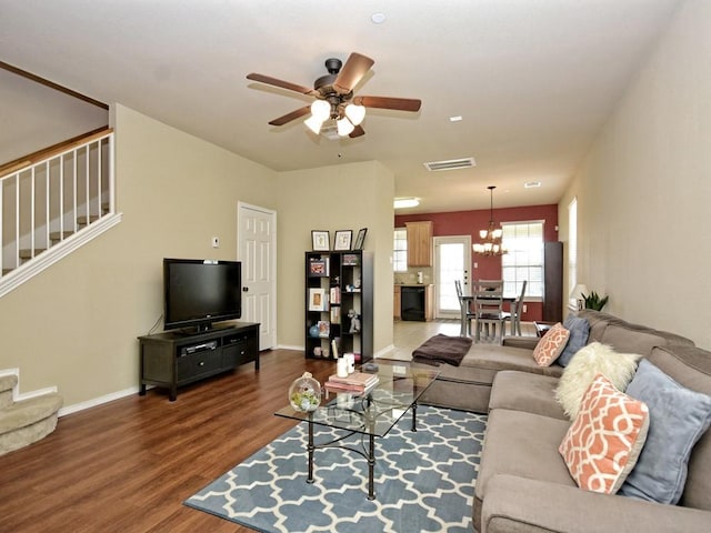 living room with wood finished floors, stairs, ceiling fan with notable chandelier, baseboards, and visible vents