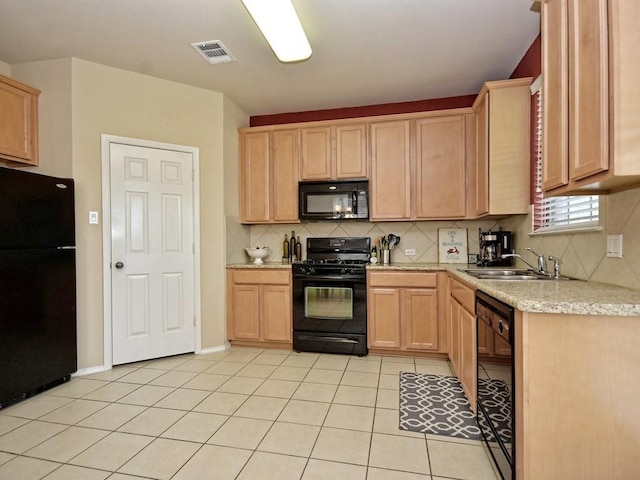 kitchen with light brown cabinetry, light countertops, visible vents, a sink, and black appliances