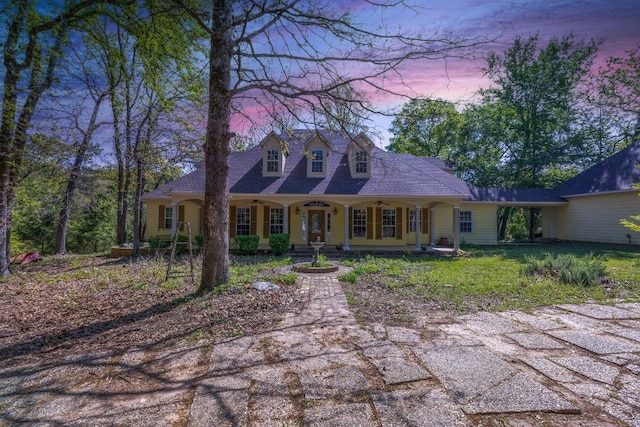 cape cod house with a porch and ceiling fan