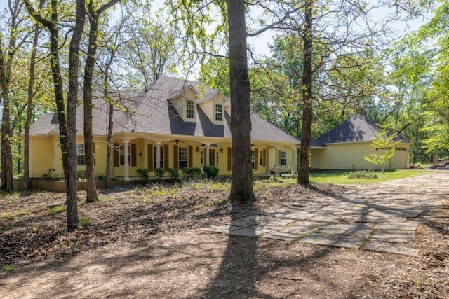 cape cod home featuring dirt driveway and a ceiling fan