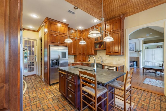 kitchen featuring brick floor, visible vents, crown molding, and stainless steel appliances