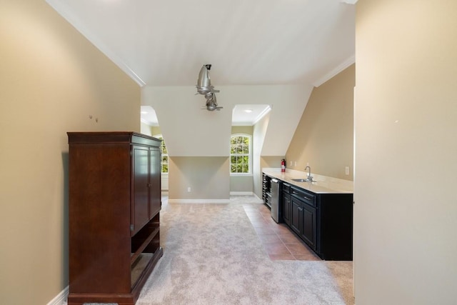 interior space with a sink, light countertops, light colored carpet, baseboards, and ornamental molding