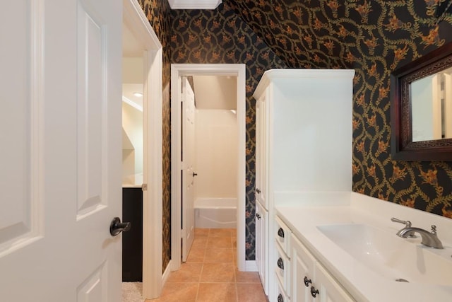 bathroom featuring a bathing tub, wallpapered walls, vanity, and tile patterned floors