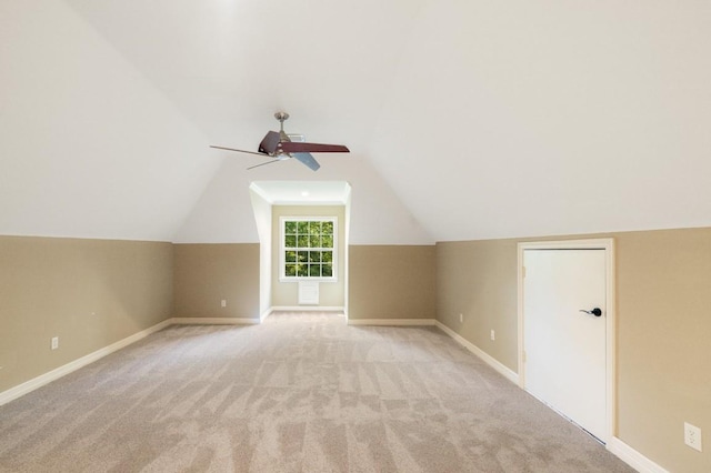 additional living space with lofted ceiling, a ceiling fan, baseboards, and light colored carpet
