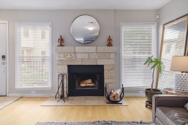 6900 E Riverside Dr Unit 24, Austin, TX 78741 - living room featuring wood finished floors, a fireplace with flush hearth, a wealth of natural light, baseboards, and visible vents