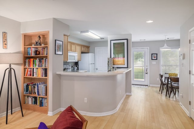 6900 E Riverside Dr Unit 24, Austin, TX 78741 - kitchen with baseboards, light countertops, white appliances, and light wood-style floors