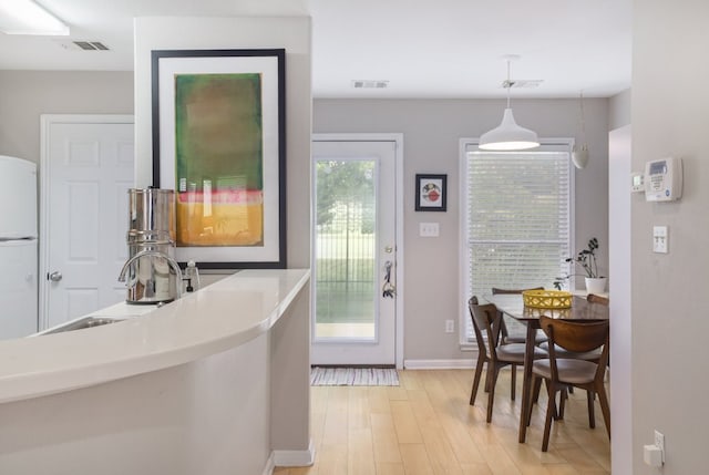 6900 E Riverside Dr Unit 24, Austin, TX 78741 - kitchen featuring decorative light fixtures, light wood finished floors, visible vents, and freestanding refrigerator