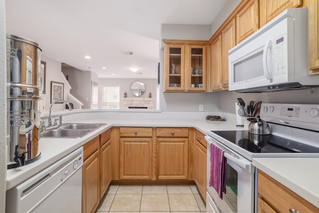 6900 E Riverside Dr Unit 24, Austin, TX 78741 - kitchen featuring light countertops, light tile patterned floors, a sink, white appliances, and glass insert cabinets