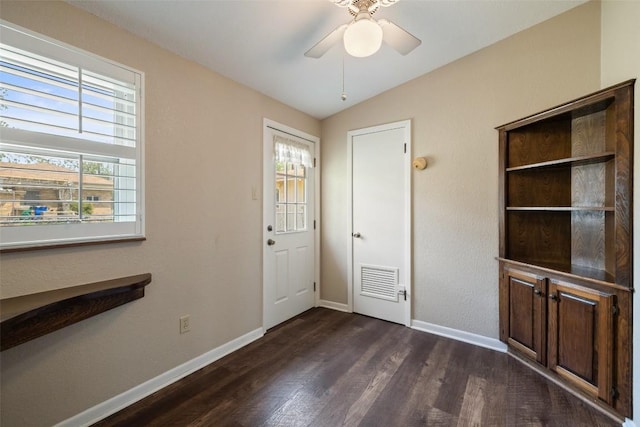 interior space with baseboards, lofted ceiling, dark wood-style floors, and a ceiling fan