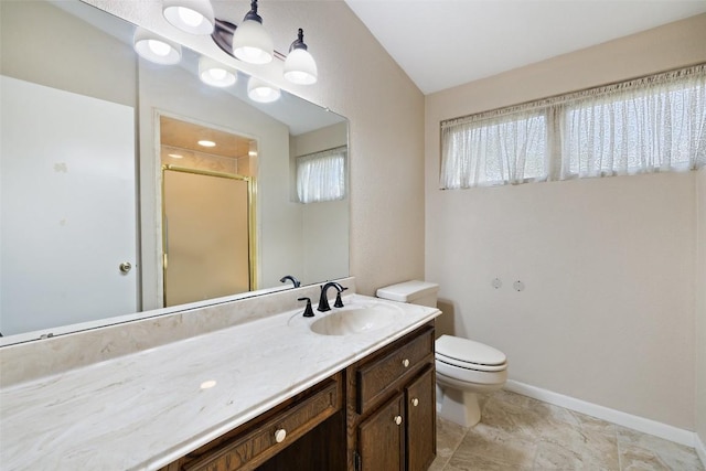 bathroom featuring toilet, baseboards, vanity, and a stall shower