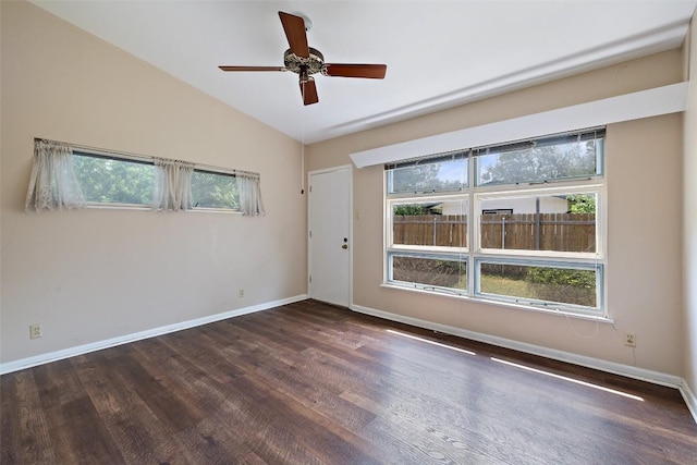 spare room with a wealth of natural light, wood finished floors, and baseboards