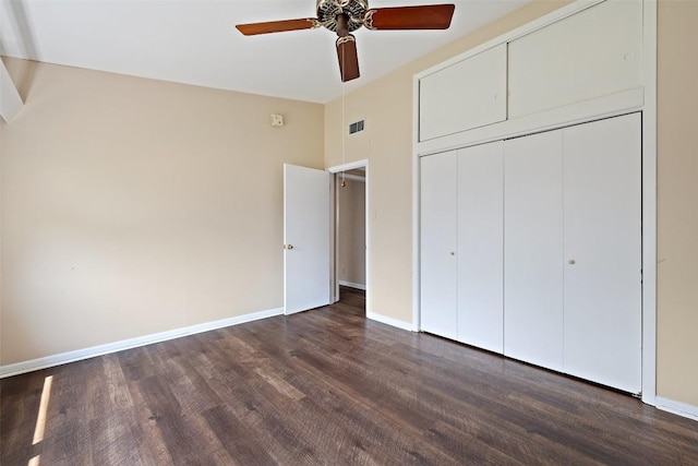 unfurnished bedroom featuring dark wood finished floors, baseboards, visible vents, a ceiling fan, and a closet
