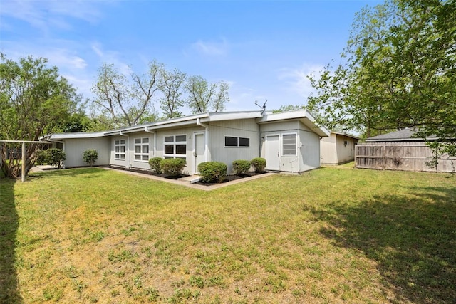 back of house with a lawn and fence
