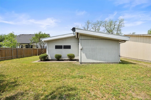 back of house featuring a yard and fence