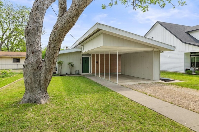 view of front of home featuring driveway, a front lawn, and an attached carport
