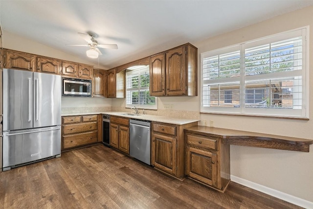 kitchen featuring stainless steel appliances, brown cabinets, and dark wood finished floors