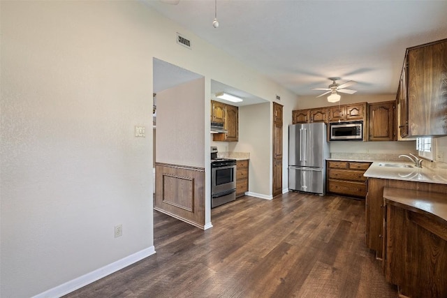 kitchen featuring stainless steel appliances, a sink, visible vents, brown cabinets, and ceiling fan