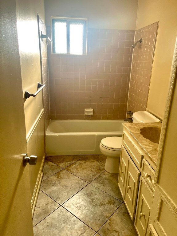 6410 Middleham Pl, Austin, TX 78745 - full bathroom featuring tile patterned floors, vanity,  shower combination, and toilet