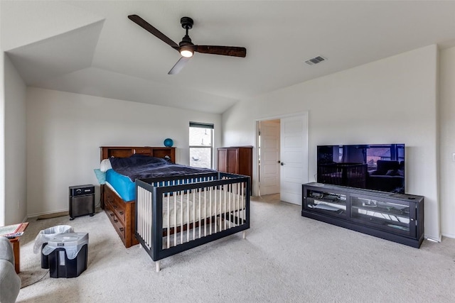 carpeted bedroom with ceiling fan, vaulted ceiling, and visible vents
