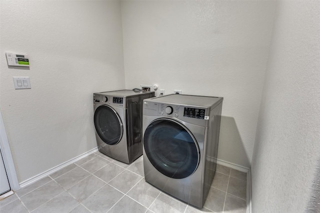washroom featuring light tile patterned floors, independent washer and dryer, baseboards, and laundry area
