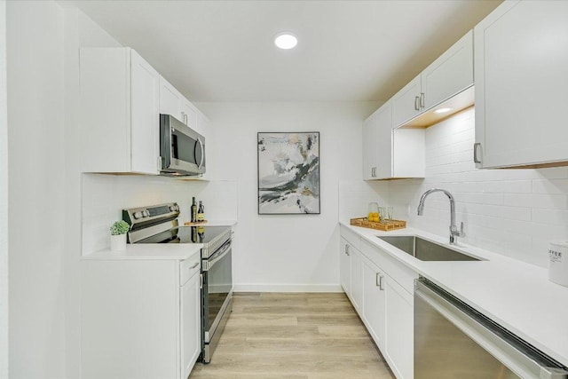 3703 Harmon Ave Unit 205, Austin, TX 78705 - kitchen with stainless steel appliances, a sink, light countertops, tasteful backsplash, and light wood-style flooring