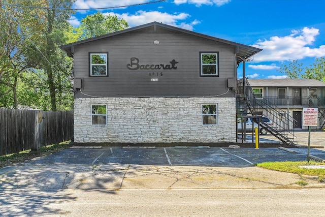3703 Harmon Ave Unit 205, Austin, TX 78705 - view of side of property featuring stone siding, uncovered parking, and stairs