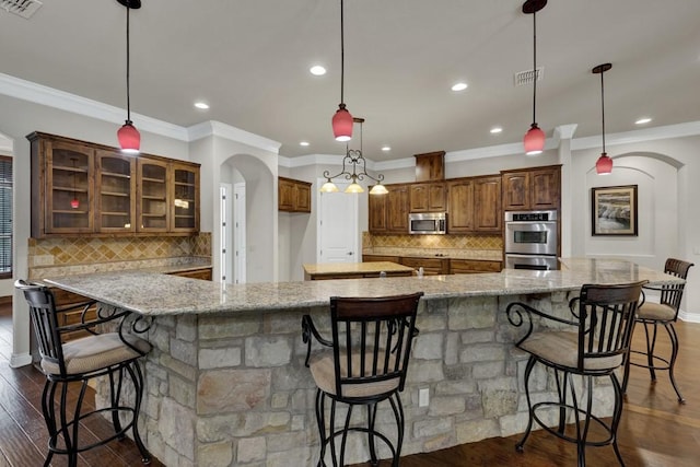 116 San Salvadore Dr, Canyon Lake, TX 78133 - kitchen with appliances with stainless steel finishes, arched walkways, ornamental molding, decorative backsplash, and light stone countertops