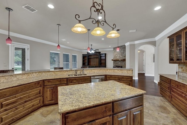 116 San Salvadore Dr, Canyon Lake, TX 78133 - kitchen with a sink, arched walkways, light stone counters, ornamental molding, and glass insert cabinets
