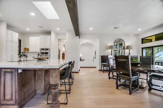 kitchen with white cabinets, recessed lighting, visible vents, and a skylight