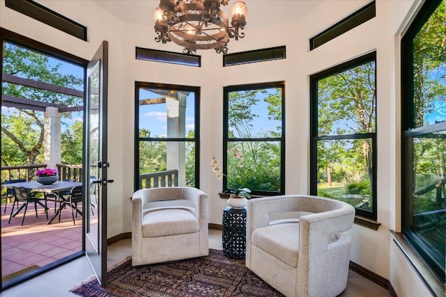 sunroom / solarium featuring a chandelier