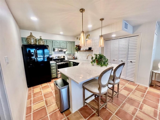 1601 Judy Lynn Dr Unit 107, Spicewood, TX 78669 - kitchen with stainless steel range with electric stovetop, freestanding refrigerator, green cabinetry, under cabinet range hood, and a peninsula