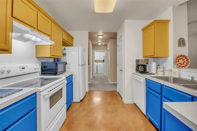 kitchen with washer / dryer, white appliances, under cabinet range hood, a sink, and blue cabinetry