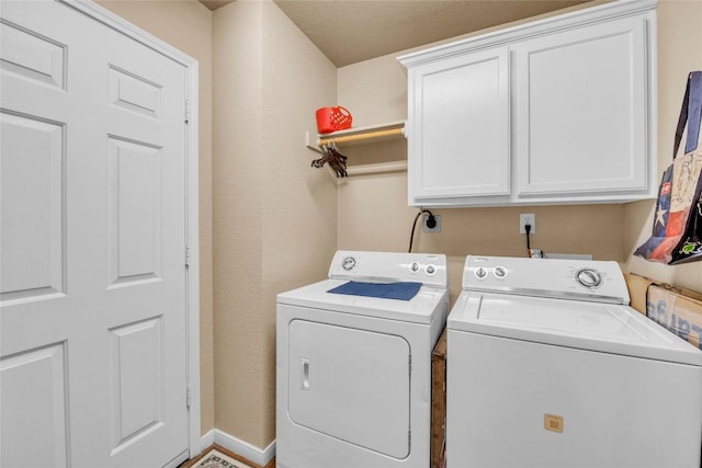 clothes washing area with cabinet space and washer and dryer