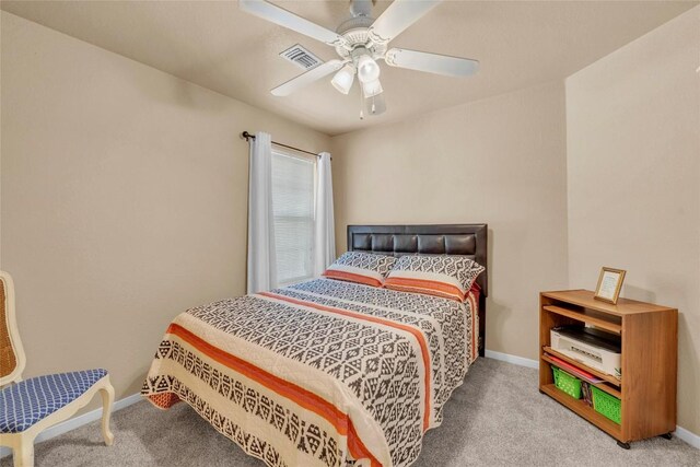 carpeted bedroom featuring a ceiling fan, baseboards, and visible vents