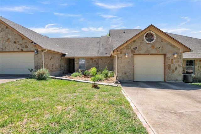 view of front of house with roof with shingles, an attached garage, stone siding, a front yard, and driveway