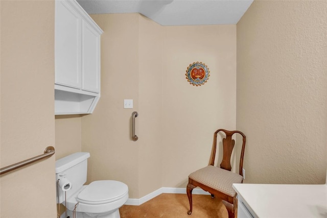 bathroom with vanity, baseboards, and toilet